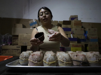 A woman manipulates molds to make chocolate skulls for sale in Mexico City, Mexico, on the eve of Day of the Dead. Sugar skulls are made fro...