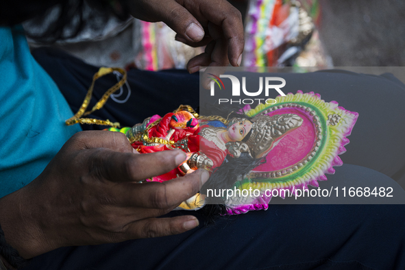 A person decorates an idol of Lakshmi for sale on the eve of the Lakshmi Puja festival in Guwahati, India, on October 15, 2024. Lakshmi is o...