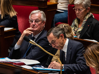 Prime Minister Michel Barnier looks at Interior Minister Bruno Retailleau's notes during question time in Parliament in Paris, France, on Oc...