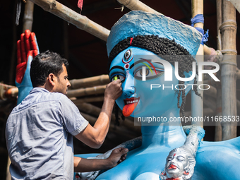 An artist makes final touches to a Hindu Goddess Kali statue for the upcoming Diwali festival at a workshop in Kolkata, India. Diwali is one...