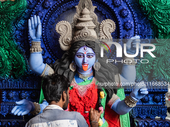 An artist makes final touches to a Hindu Goddess Kali statue for the upcoming Diwali festival at a workshop in Kolkata, India. Diwali is one...