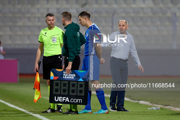 In Ta' Qali, Malta, on October 13, 2024, Serghei Clescenco, head coach of Moldova, speaks to Dmitri Mandricenco before a substitution during...