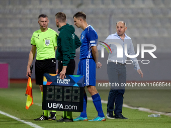 In Ta' Qali, Malta, on October 13, 2024, Serghei Clescenco, head coach of Moldova, speaks to Dmitri Mandricenco before a substitution during...