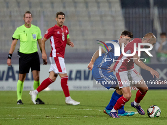 In Ta' Qali, Malta, on October 13, 2024, Teddy Teuma of Malta moves away with the ball from Dmitri Mandricenco of Moldova during the UEFA Na...