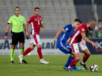 In Ta' Qali, Malta, on October 13, 2024, Teddy Teuma of Malta moves away with the ball from Dmitri Mandricenco of Moldova during the UEFA Na...