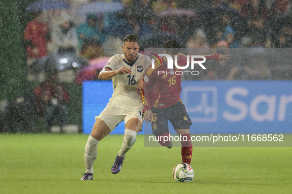 In Cordoba, Spain, on October 15, 2024, Alex Baena of Spain competes for the ball with Strahinja Erakovic of Serbia during the UEFA Nations...