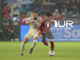 In Cordoba, Spain, on October 15, 2024, Alex Baena of Spain competes for the ball with Strahinja Erakovic of Serbia during the UEFA Nations...