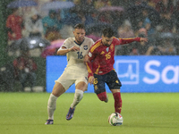 In Cordoba, Spain, on October 15, 2024, Alex Baena of Spain competes for the ball with Strahinja Erakovic of Serbia during the UEFA Nations...