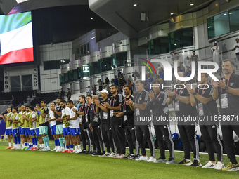 Juan Pizzi, head coach of Kuwait, his staff, and substitutes line up for the national anthem before the FIFA World Cup 2026 Qualification 3r...