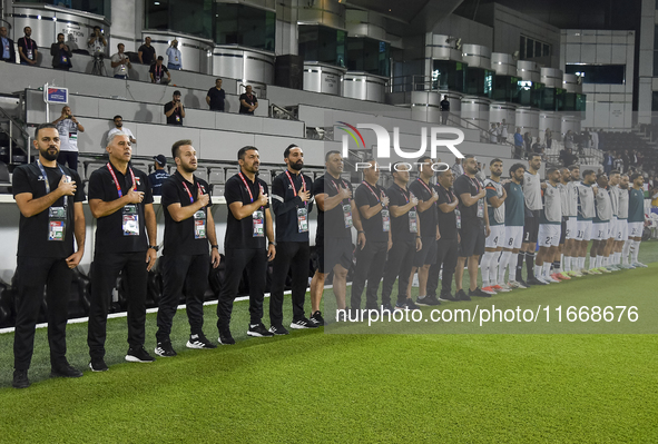 Makram Daboub, Head Coach of Palestine, his staff, and substitutes line up for the national anthem before the FIFA World Cup 2026 Qualificat...