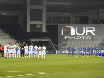 Players observe a moment of silence before the FIFA World Cup 2026 Qualification 3rd Round group B match between Palestine and Kuwait at Jas...