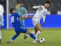 Wessam Abouli of Palestine battles for the ball with Athbi Saleh of Kuwait during the FIFA World Cup 2026 Qualification 3rd Round group B ma...