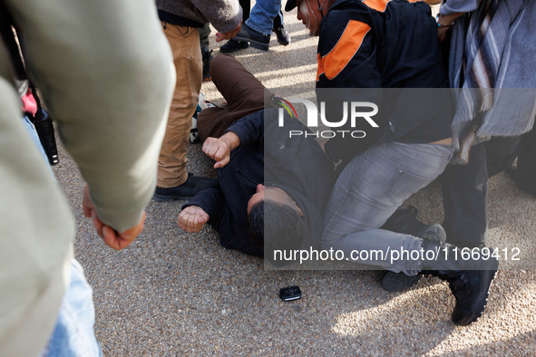 An Indigenous demonstrator falls to the ground during a clash with police near the U.S. Capitol in Washington, D.C. on October 15, 2024 afte...