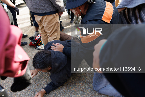 An Indigenous demonstrator falls to the ground during a clash with police near the U.S. Capitol in Washington, D.C. on October 15, 2024 afte...