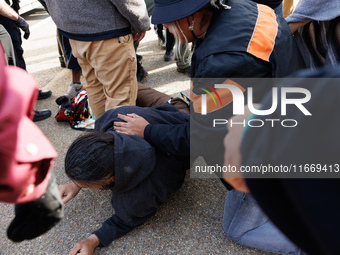 An Indigenous demonstrator falls to the ground during a clash with police near the U.S. Capitol in Washington, D.C. on October 15, 2024 afte...