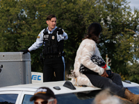 A U.S. Park Police officer speaks with an Indigenous demonstrator sitting atop a vehicle attached to a horse trailer near the U.S. Capitol i...