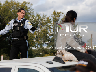 A U.S. Park Police officer speaks with an Indigenous demonstrator sitting atop a vehicle attached to a horse trailer near the U.S. Capitol i...