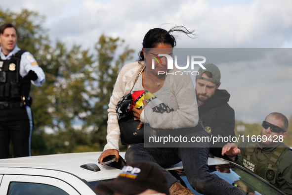 A U.S. Park Police officer speaks with an Indigenous demonstrator sitting atop a vehicle attached to a horse trailer near the U.S. Capitol i...