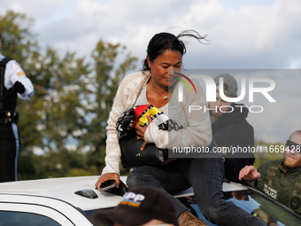 A U.S. Park Police officer speaks with an Indigenous demonstrator sitting atop a vehicle attached to a horse trailer near the U.S. Capitol i...