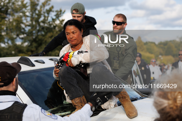 A U.S. Park Police officer speaks with an Indigenous demonstrator sitting atop a vehicle attached to a horse trailer near the U.S. Capitol i...