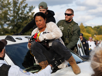 A U.S. Park Police officer speaks with an Indigenous demonstrator sitting atop a vehicle attached to a horse trailer near the U.S. Capitol i...