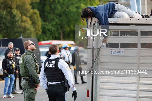 U.S. Park Police officers speak with an Indigenous demonstrator sitting atop a horse trailer near the U.S. Capitol in Washington, D.C. on Oc...