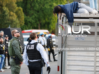 U.S. Park Police officers speak with an Indigenous demonstrator sitting atop a horse trailer near the U.S. Capitol in Washington, D.C. on Oc...