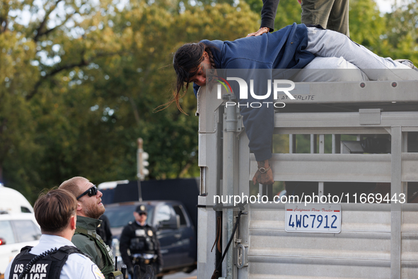 U.S. Park Police officers speak with an Indigenous demonstrator sitting atop a horse trailer near the U.S. Capitol in Washington, D.C. on Oc...