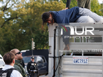 U.S. Park Police officers speak with an Indigenous demonstrator sitting atop a horse trailer near the U.S. Capitol in Washington, D.C. on Oc...