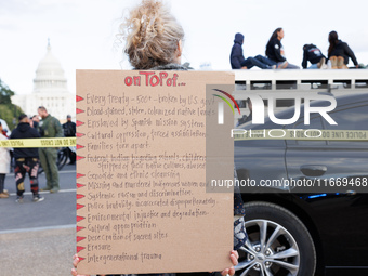 A woman wears a protest sign as police surround a horse trailer after Indigenous demonstrators clash with police near the U.S. Capitol in Wa...