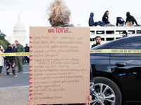 A woman wears a protest sign as police surround a horse trailer after Indigenous demonstrators clash with police near the U.S. Capitol in Wa...