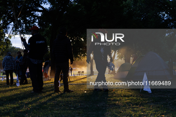 The sun sets behind an encampment erected by members of the Muwekma Ohlone Tribe of the San Francisco Bay Area, along with other tribal grou...