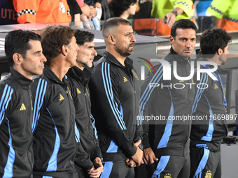 Lionel Scaloni, head coach of Argentina, and his assistant coaches stand during the national anthems ceremony before a match between Argenti...