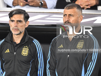 Roberto Ayala and Walter Samuel, assistant coaches of Argentina, stand during the national anthems ceremony before a match between Argentina...