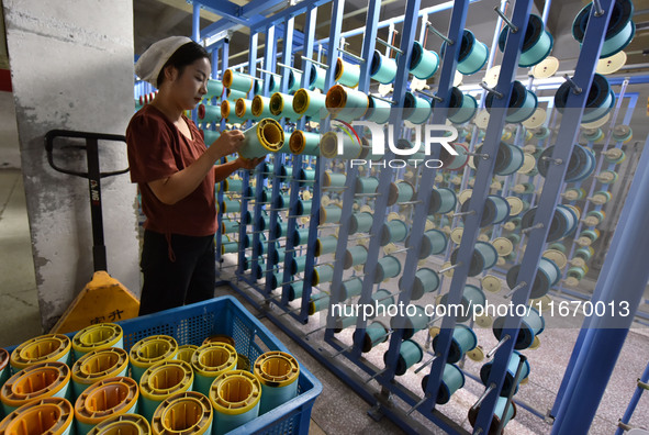 A worker works at a silk product production line of Anhui Jingjiu Silk Co in Fuyang, China, on October 16, 2024. 