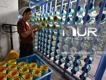 A worker works at a silk product production line of Anhui Jingjiu Silk Co in Fuyang, China, on October 16, 2024. (