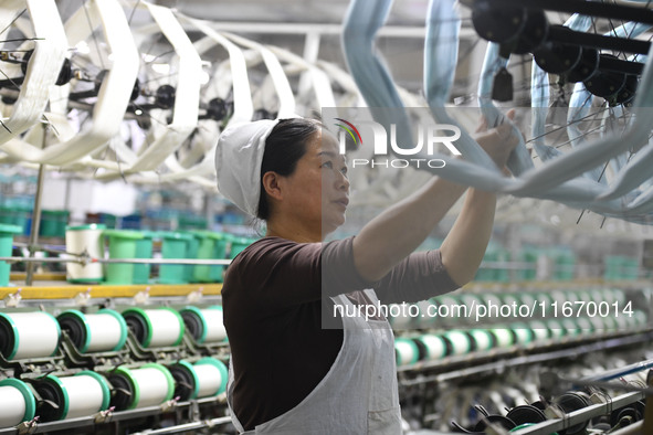 A worker works at a silk product production line of Anhui Jingjiu Silk Co in Fuyang, China, on October 16, 2024. 