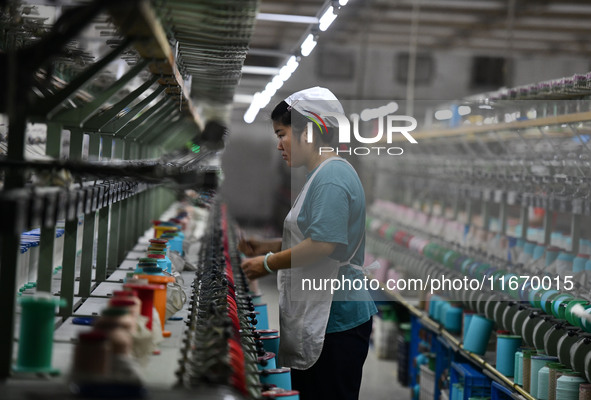 A worker works at a silk product production line of Anhui Jingjiu Silk Co in Fuyang, China, on October 16, 2024. 