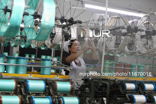 A worker works at a silk product production line of Anhui Jingjiu Silk Co in Fuyang, China, on October 16, 2024. 