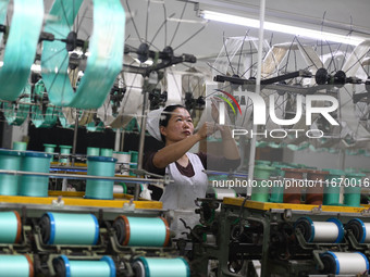 A worker works at a silk product production line of Anhui Jingjiu Silk Co in Fuyang, China, on October 16, 2024. (