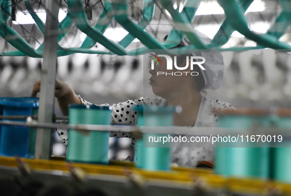 A worker works at a silk product production line of Anhui Jingjiu Silk Co in Fuyang, China, on October 16, 2024. 