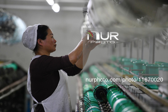 A worker works at a silk product production line of Anhui Jingjiu Silk Co in Fuyang, China, on October 16, 2024. 