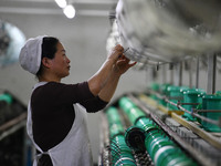 A worker works at a silk product production line of Anhui Jingjiu Silk Co in Fuyang, China, on October 16, 2024. (