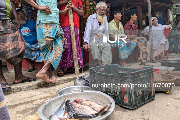 Fishermen sell fish in the early morning in a rural area in Feni, Bangladesh, on October 16, 2024. Many fish enclosures and ponds are washed...