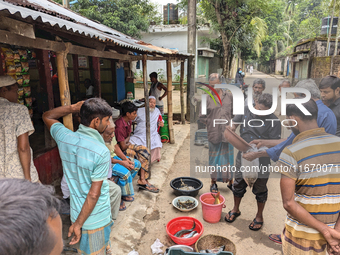 Fishermen sell fish in the early morning in a rural area in Feni, Bangladesh, on October 16, 2024. Many fish enclosures and ponds are washed...