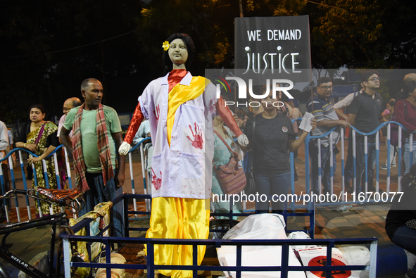 People stand behind an idol wearing a doctor's coat as they attend the 'Droh carnival', the human-chain protest demonstration against the ra...