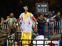 People stand behind an idol wearing a doctor's coat as they attend the 'Droh carnival', the human-chain protest demonstration against the ra...