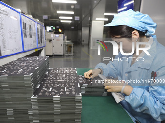 A worker produces an LED display at a workshop in Huai'an City, Jiangsu Province, China, on October 16, 2024. (