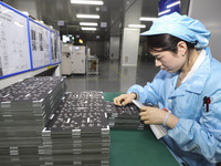 A worker produces an LED display at a workshop in Huai'an City, Jiangsu Province, China, on October 16, 2024. (