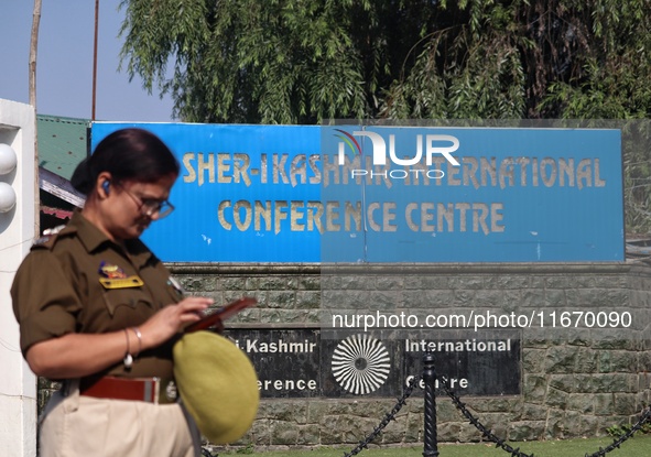 An Indian policewoman stands alert as Jammu and Kashmir and National Conference (NC) Vice President Omar Abdullah arrives to take the oath a...